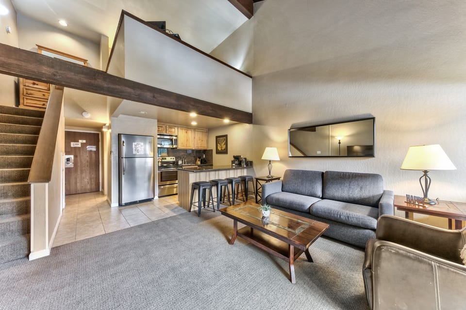 Relax in your spacious loft with soaring ceilings, exposed beams, and modern amenities. The open layout connects your cozy living area to a fully equipped kitchen.