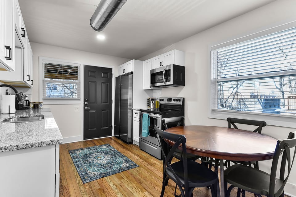 Your fully equipped kitchen and dining space features granite counters, stainless appliances, and warm wood floors perfect for home-cooked meals.