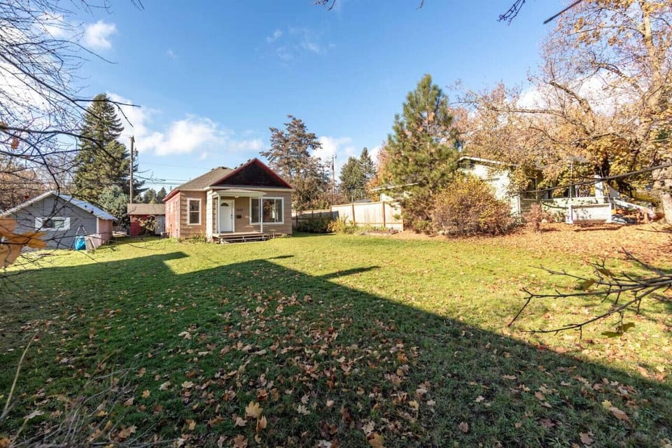 The home’s exterior showcases a charming design, complemented by a large, yard that offers ample space for outdoor activities and relaxation. Surrounded by lush greenery, this peaceful backyard provides a perfect retreat for enjoying the fresh air