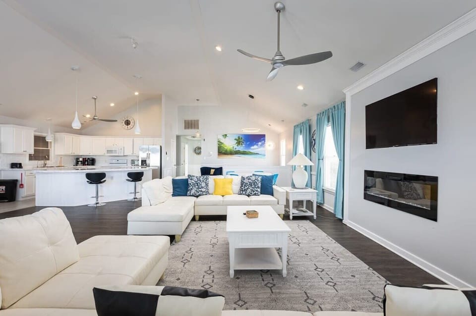 Top Level: Expansive living area with TV & electric fireplace, well-stocked kitchen, island bar seating for 5, dining for 10, horizon ocean & sound views.