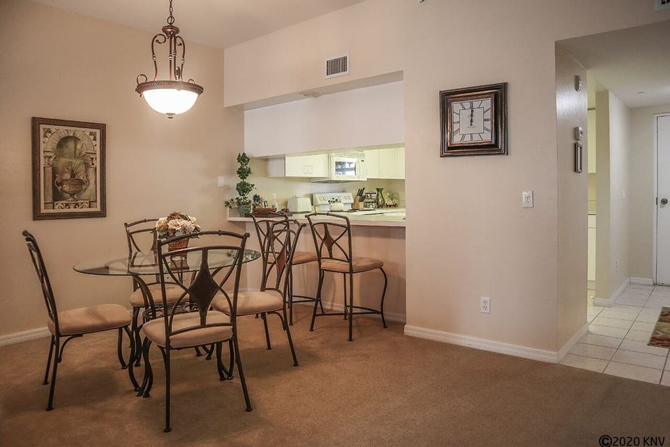 Dining area has a table for four and a breakfast bar that seats two