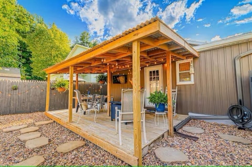 Relax on the covered back deck with a fire table, dining table, and smart TV.
