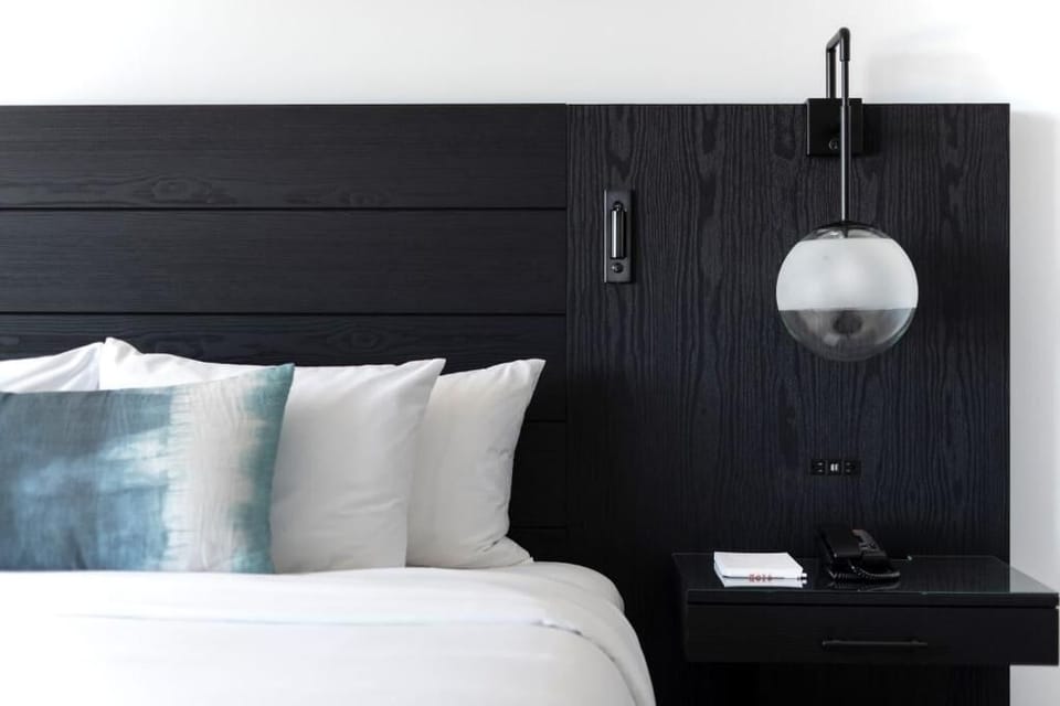 Sink into crisp linens beside soft-glow bedside lighting.