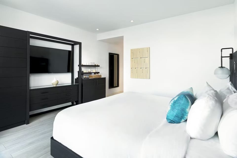 Unwind in crisp linens with sleek media wall comfort.