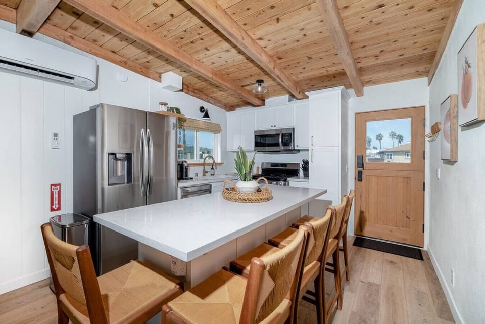 Enjoy the convenience of a spacious kitchen island, complete with five sleek barstools for comfortable seating and casual dining.