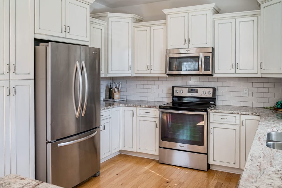 kitchen includes stainless refrigerator, stove, microwave, sink, and dishwasher.