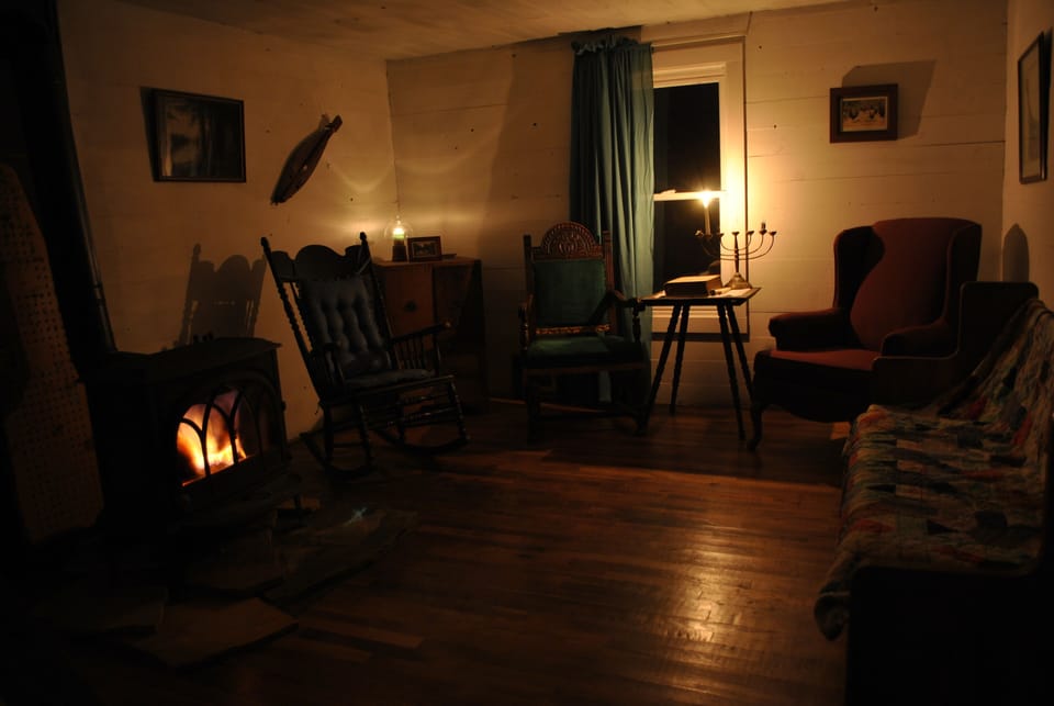 living room in evening candlelight with glow of wood stove