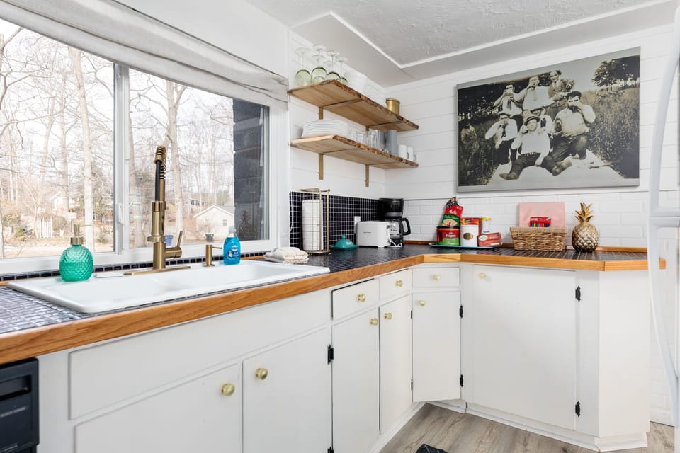 Bright kitchen corner w/ wraparound counters, open shelving & plenty of space to prep meals.
