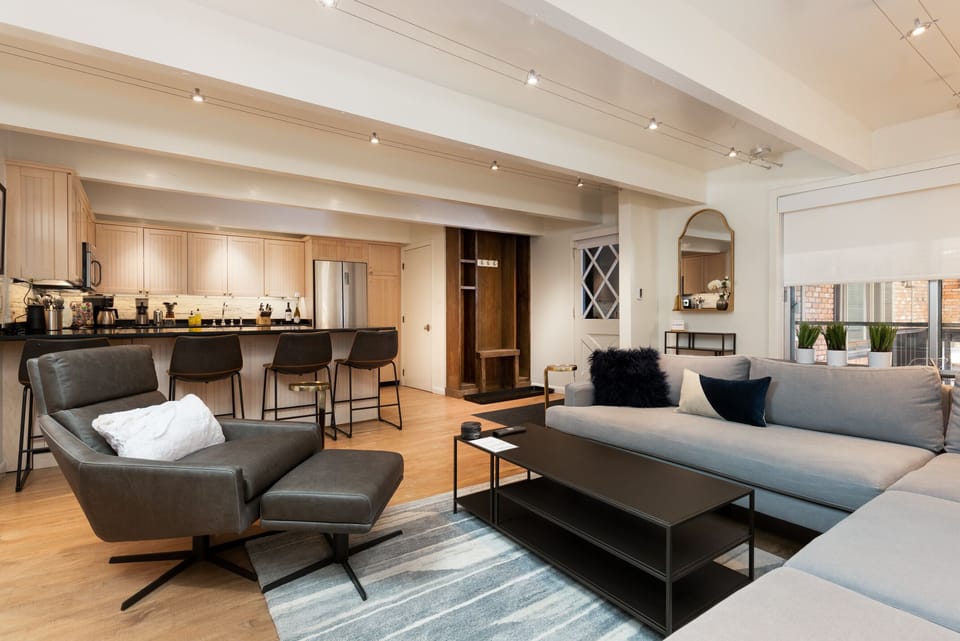 Living room with view into kitchen & bar seating.