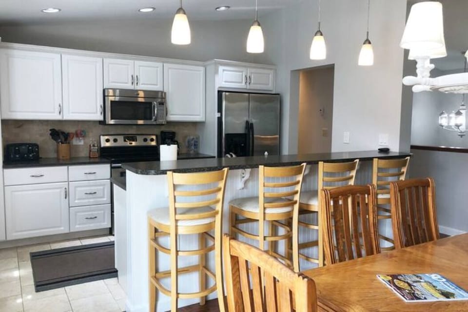 Fully stocked kitchen open to the dining room w/ counter space and 4 bar stools