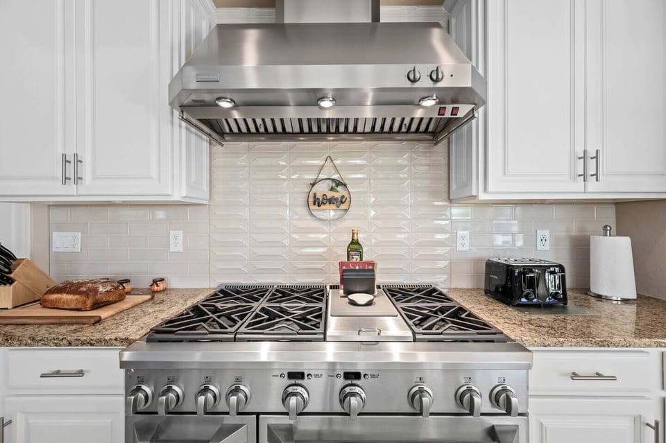 Unleash your culinary creativity in the kitchen, where a large 6 burner stove, complete with a vent hood and double oven takes center stage.