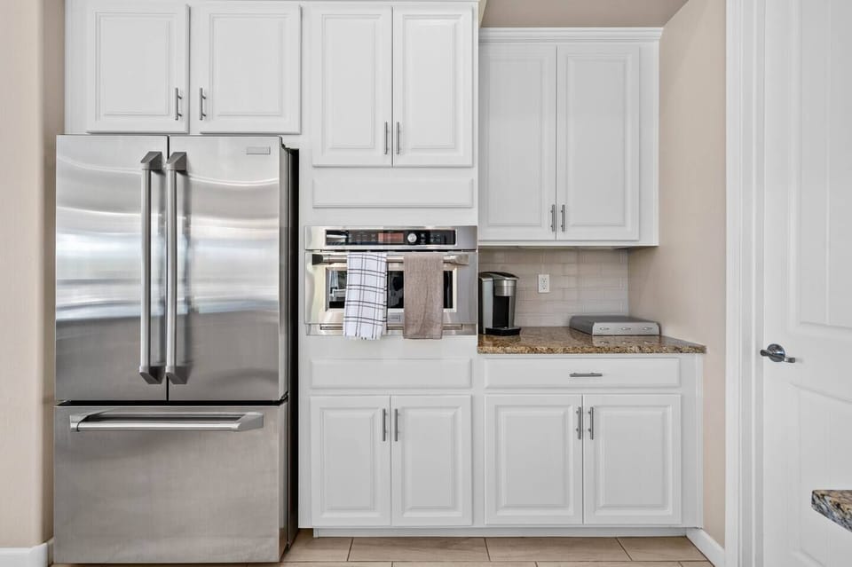 This well appointed kitchen features a stainless steel refrigerator and freezer combo, microwave and Keurig coffee machine. 