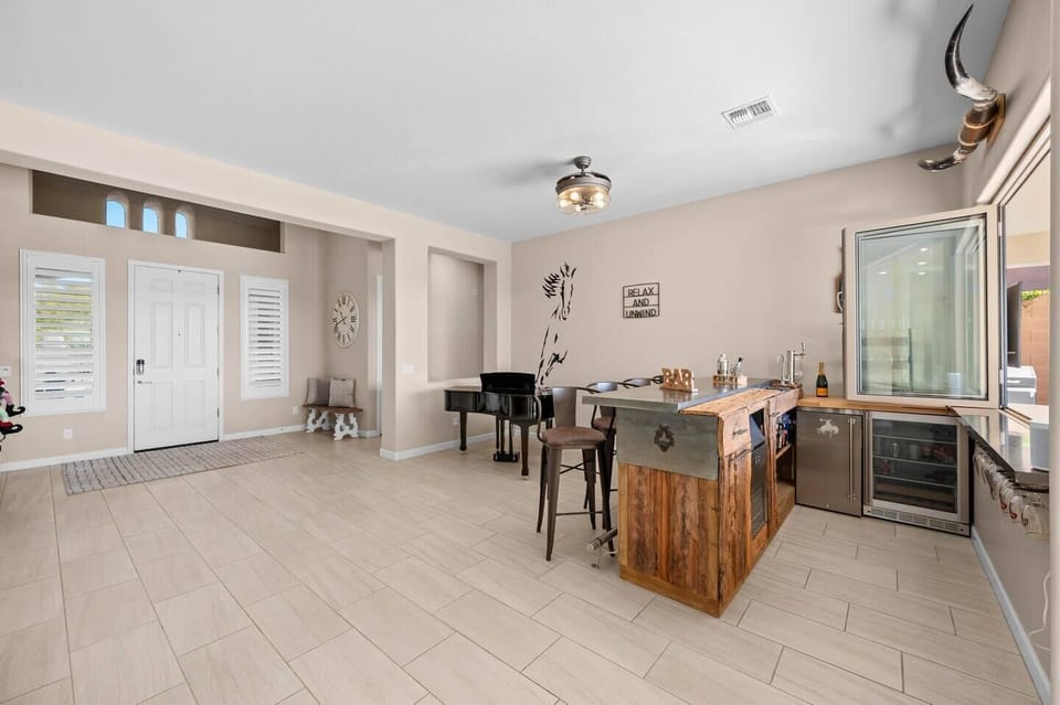 Welcome your friends and family with a touch of elegance as they enter through the front door. The bar, a stylish focal point, becomes the perfect spot to greet your guests. 