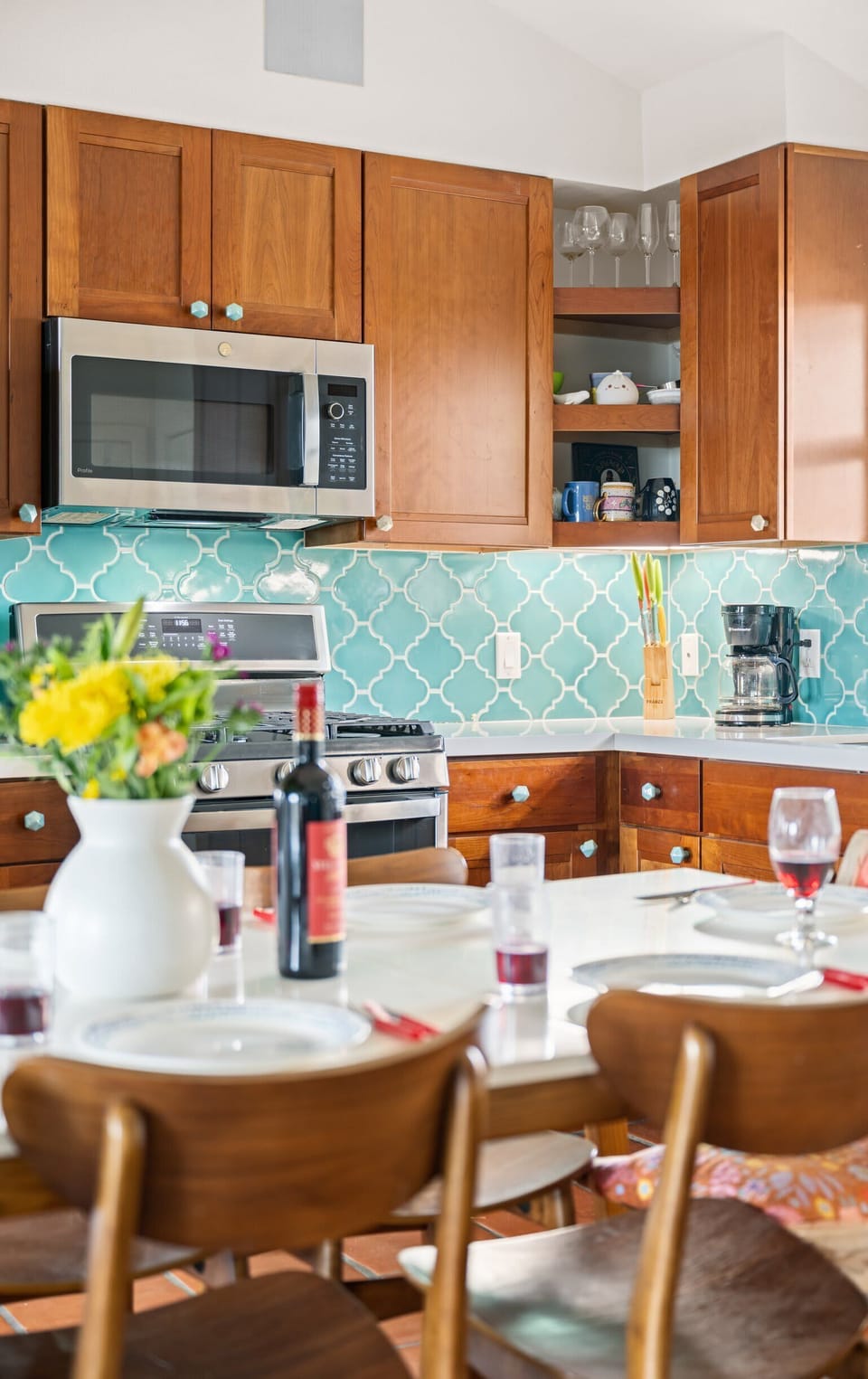 Kitchen & Dining — Turquoise Backsplash, Gas Range, Microwave, Wine & Flowers on Table