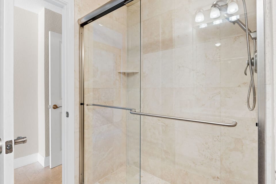 Bright master bathroom featuring double vanity and walk-in shower convenience.