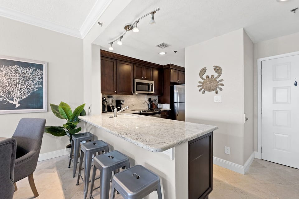 Fully equipped kitchen with bar seating for four and Gulf views.