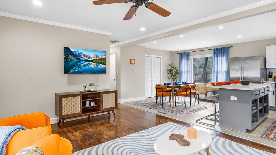 Living room with large flat screen tv, sowing a peep of the dining area