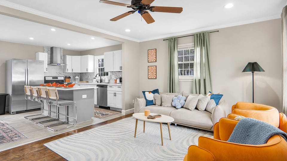 Open concept area featuring vibrant living room and kitchen with kitchen island