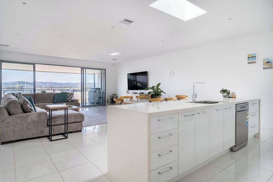 The sleek kitchen is designed around a central island and is fit with high-quality appliances and cooking utensils.
