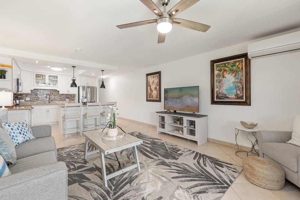 Open living area with sofa, TV, and seamless flow to kitchen and dining.