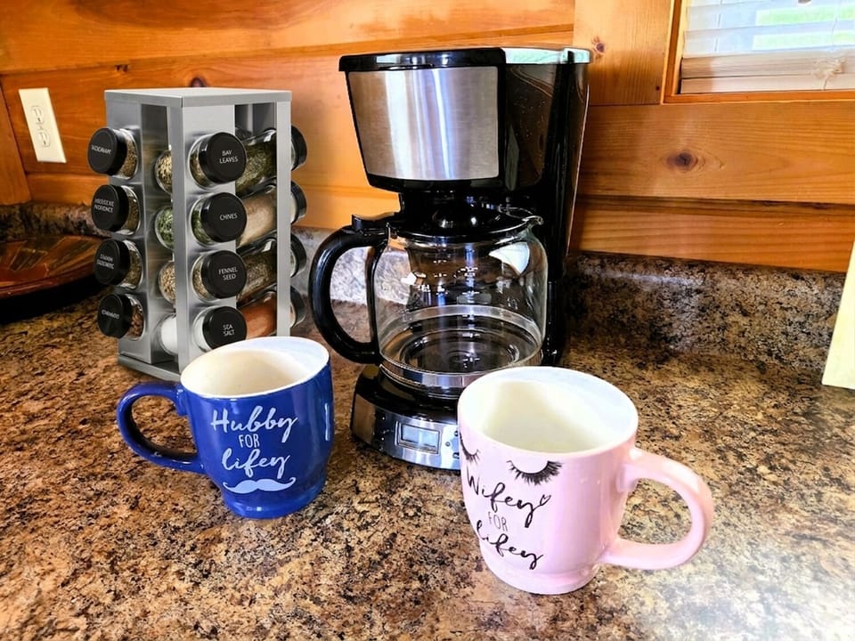 Enjoy a fresh brew with couple's mugs and a spice rack for culinary creations.