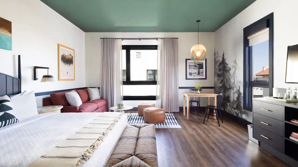 Unwind in a bright studio room with cozy seating and workspace.