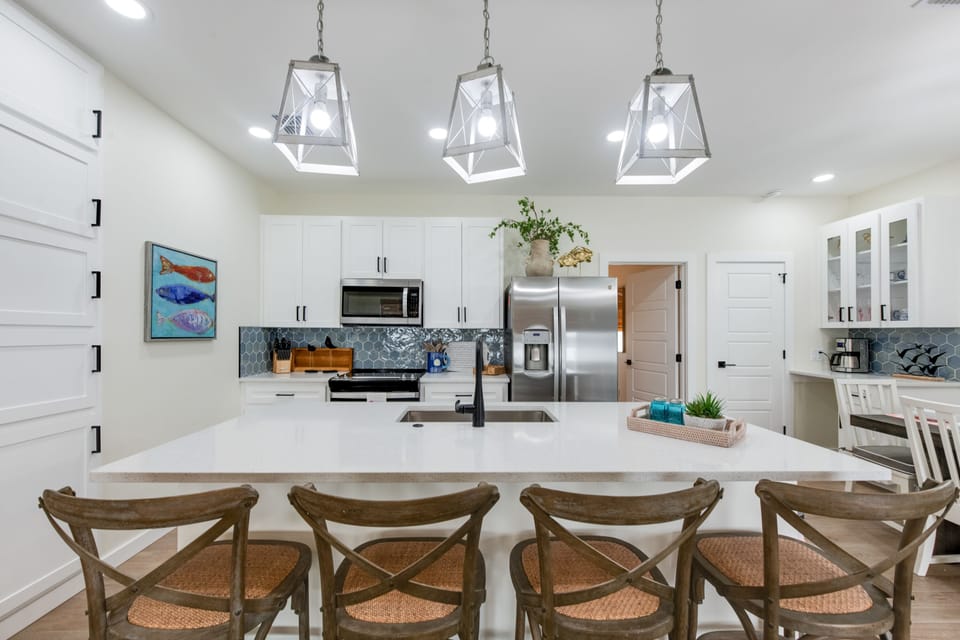 A stylish kitchen island anchors the space, blending function with coastal charm