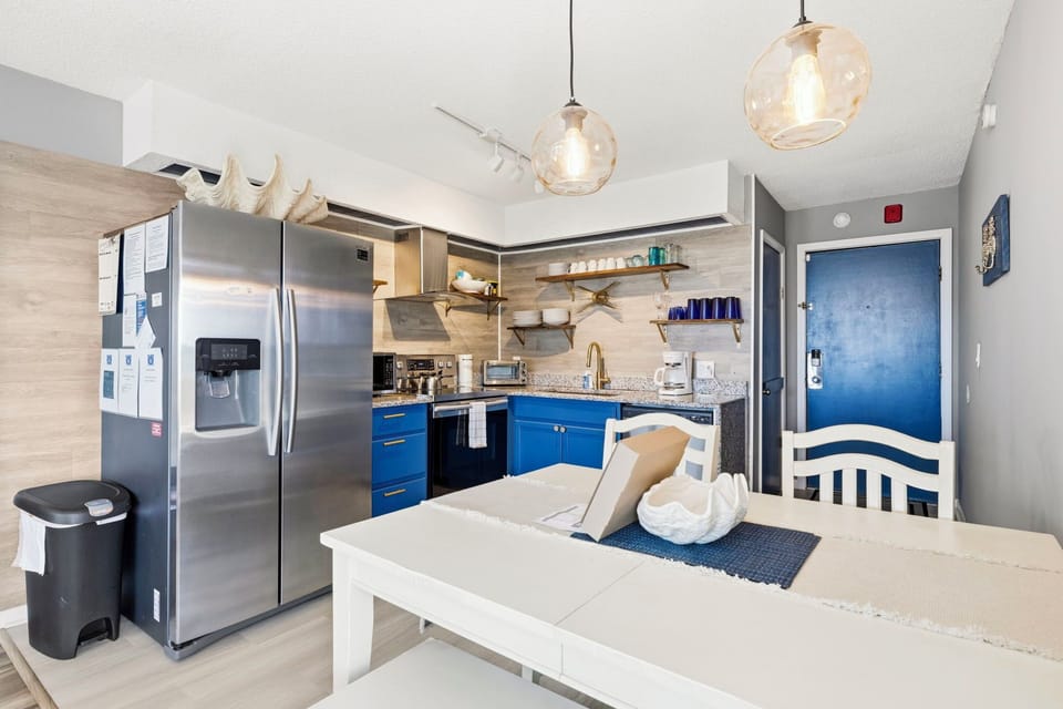 Bright modern kitchen with dining table, and stainless appliances