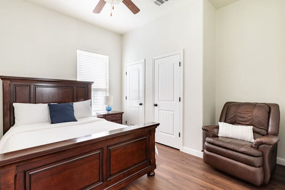 Second bedroom with a queen bed, comfy leather couch, and soft bedding with extra pillows and blankets for a restful night.