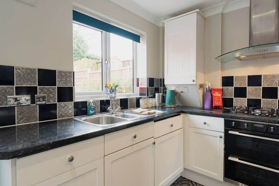 The Kitchen: Looking out over the beautiful garden, there is plenty of storage and all amenities provided.
