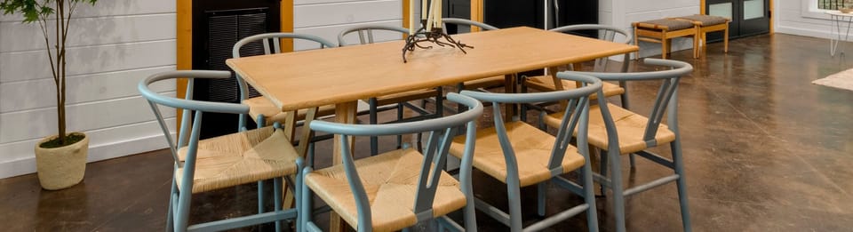 The dining room showcases a sturdy wooden table accompanied by chairs with a touch of color that adds vibrancy to the room