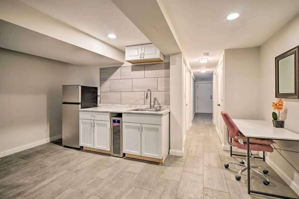 Basement kitchenette, additional bedrooms and bath down hallway, workspace and access to backyard