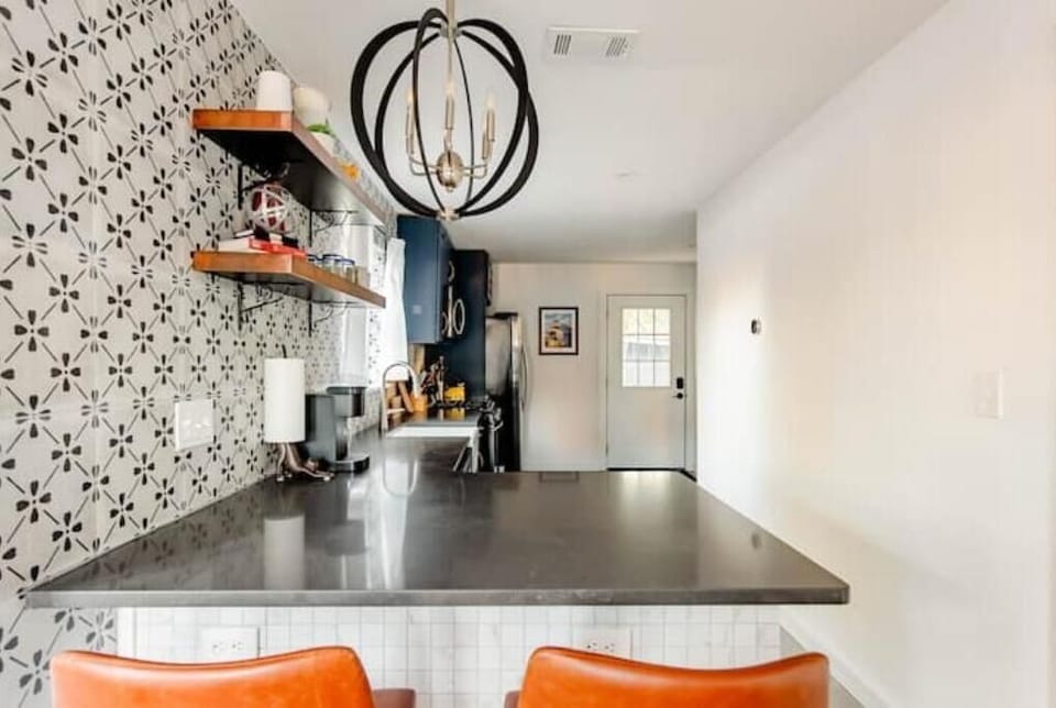 Kitchen has counter with 2 stools. 