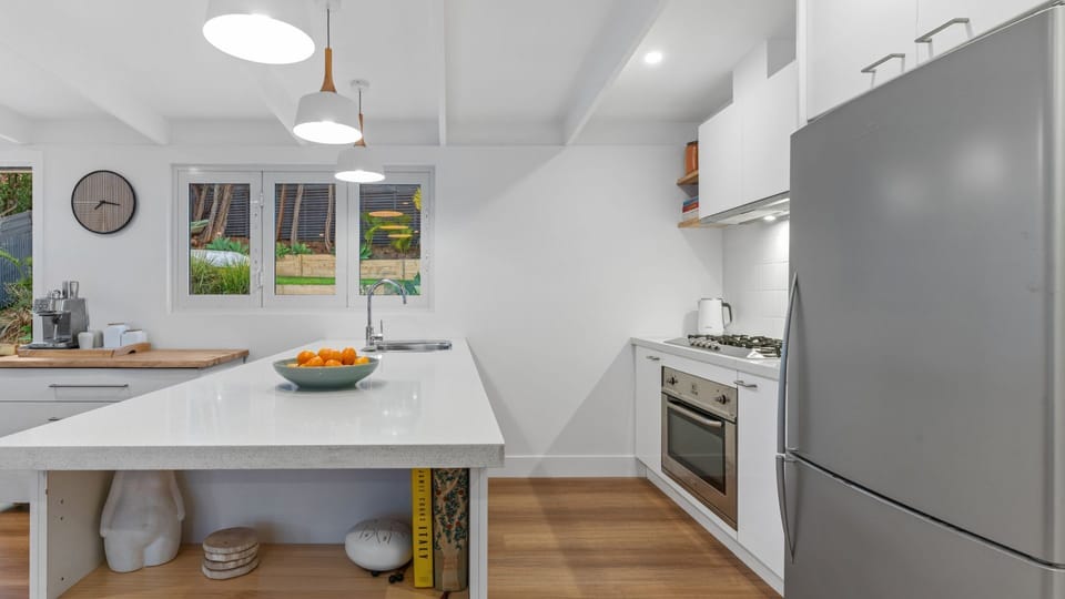 Fully equipped kitchen with bi-fold windows that open up to the alfresco bar with stools. Perfect for entertaining. 