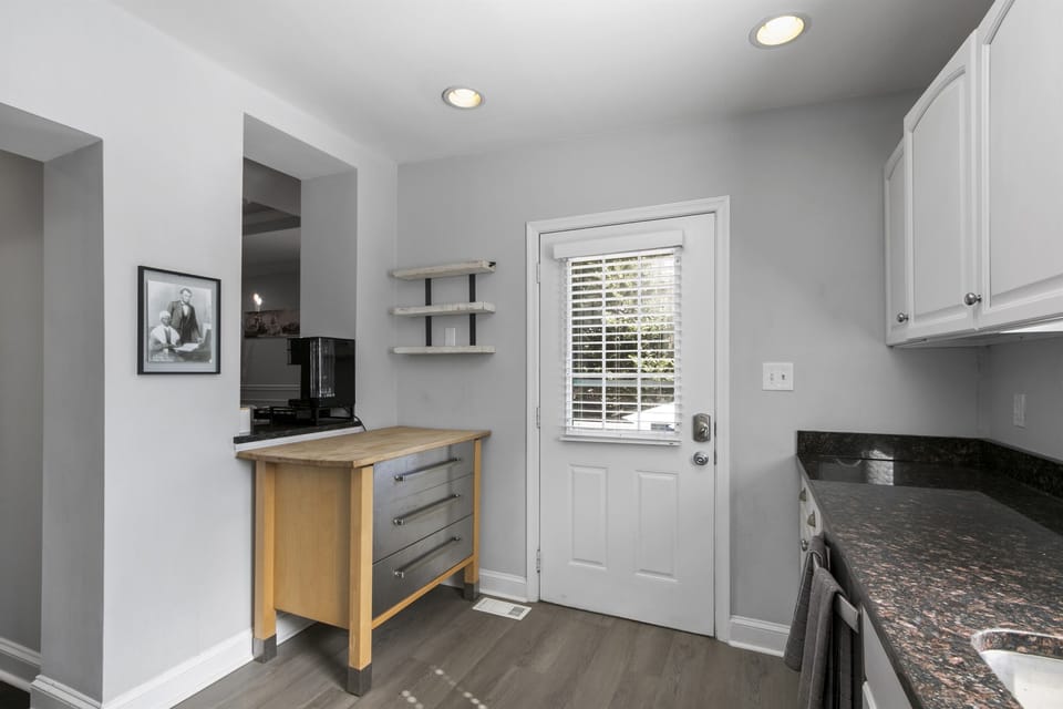 Kitchen door opens onto backyard patio, extending culinary delights outdoors.