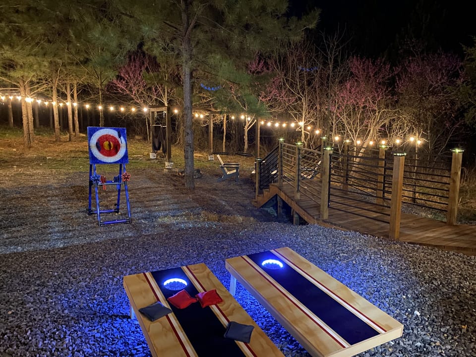Cozy backyard retreat with string lights, games, and axe throwing fun.