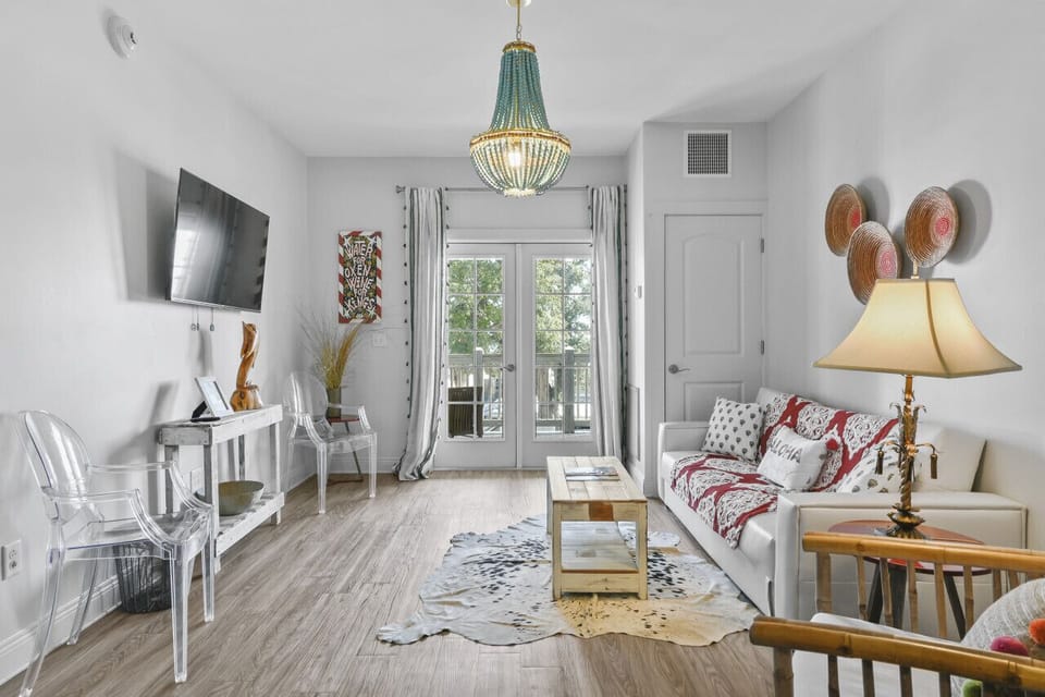 Bright and airy, the living room of King Suite 302 offers a stylish coastal retreat with French doors opening to your private balcony.
