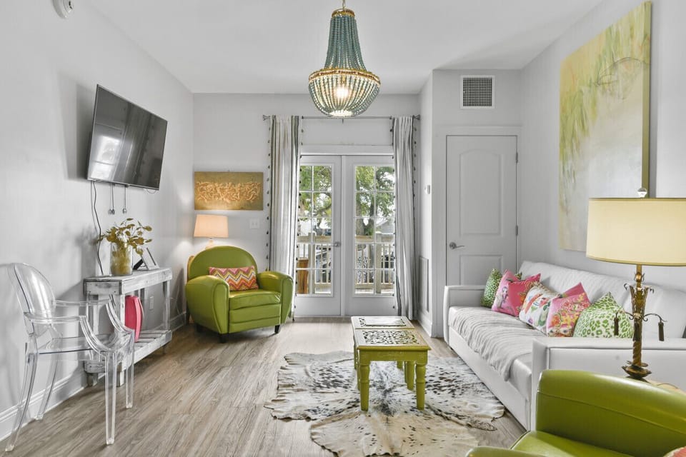 Coastal charm meets comfort in the living area of King Suite 302—featuring chic decor, natural light, and access to your private balcony.