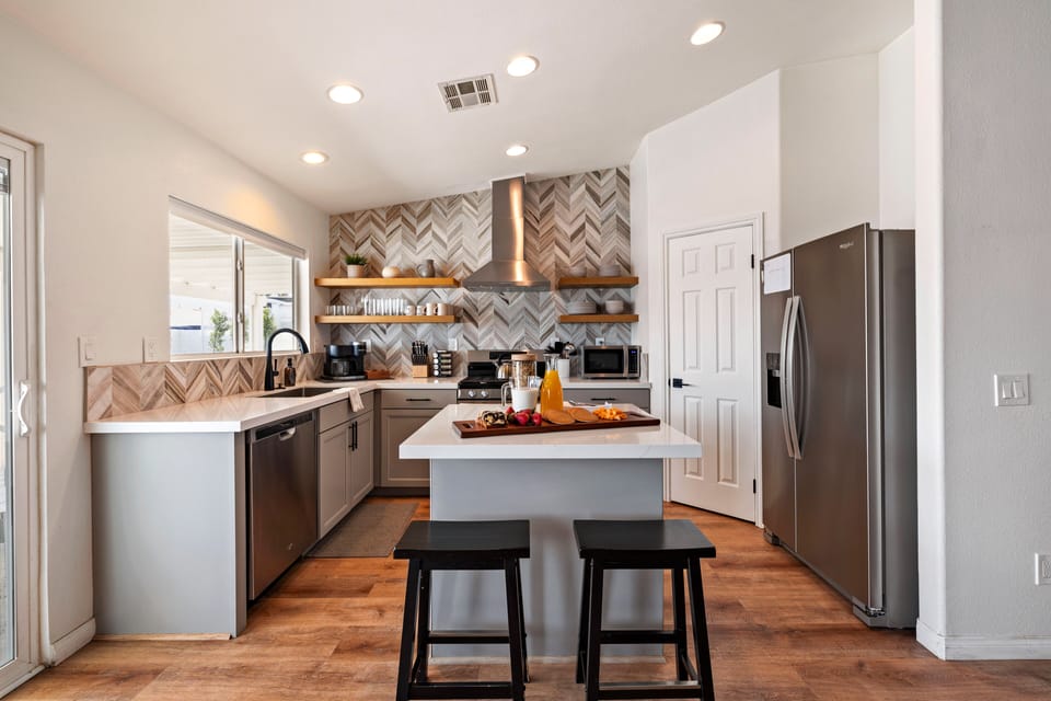 Kitchen features an island with barstool seating.
