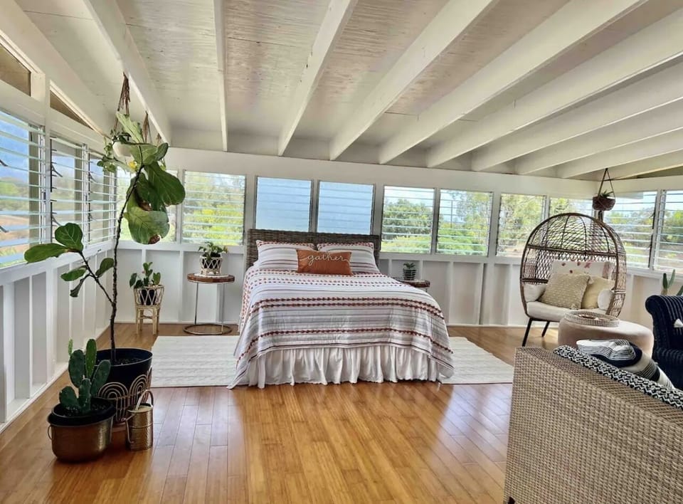 Queen bed in living room. Curtians can make a type of separation for living room
