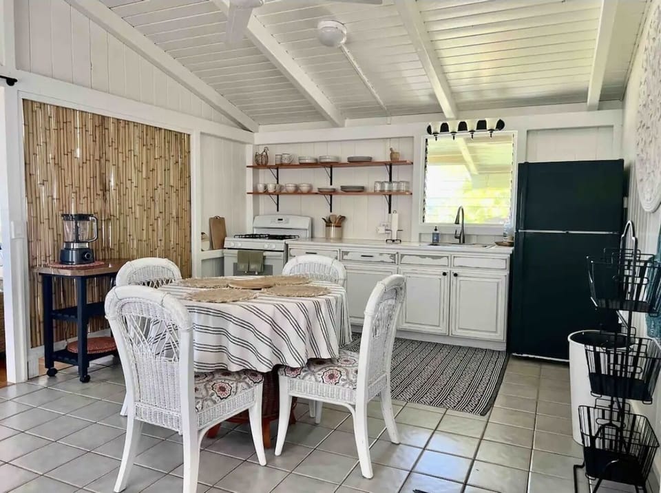 Kitchen and dining room with table for 4 and 2 seater couch.