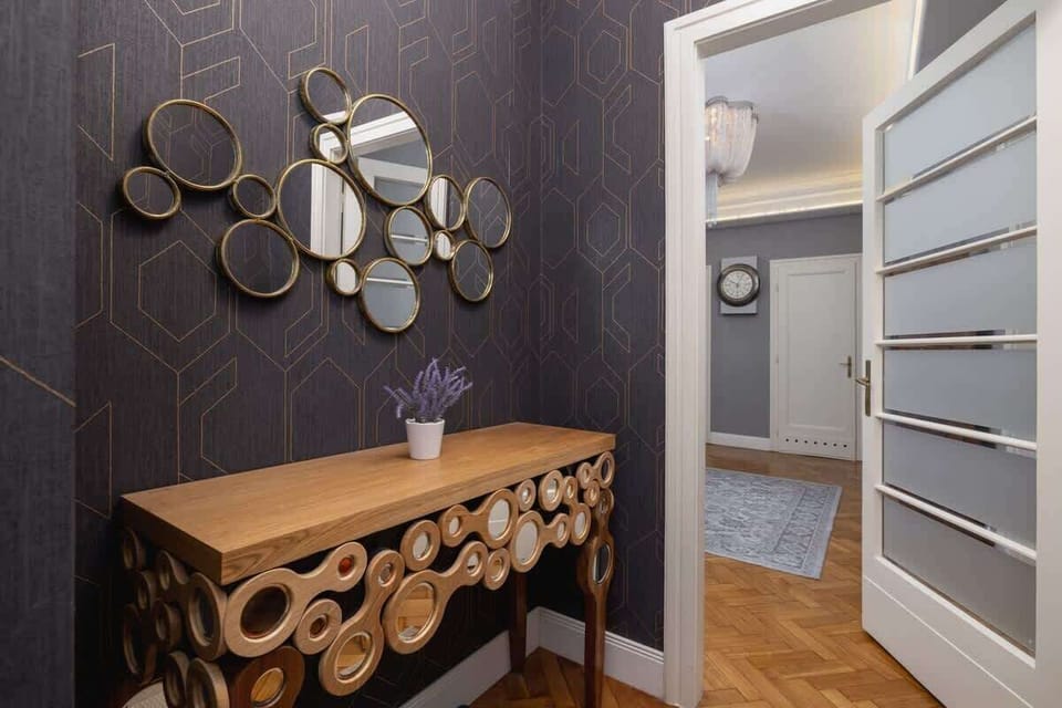 A welcoming hallway with a vintage wooden cabinet, a mirror, and a rug.