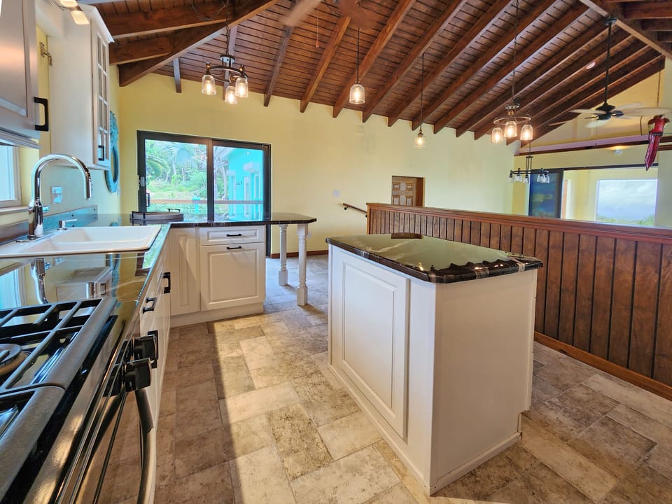 Kitchen with above the sink window of lush front yard.
