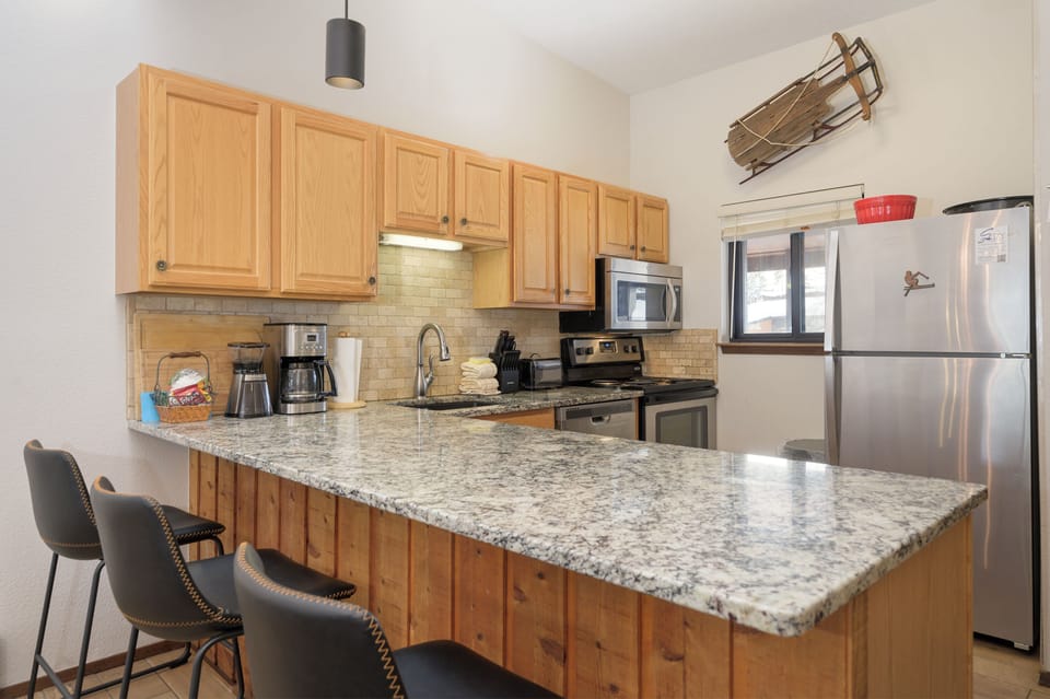 Cook your favorite meals in this fully equipped kitchen with granite counters, stainless appliances, and a breakfast bar for casual dining.