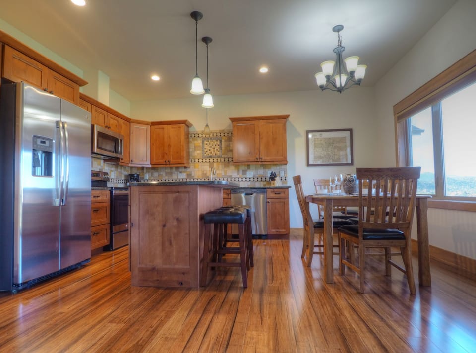 Open concept kitchen and dinning table for 6, Large refrigerator, and electric stove.