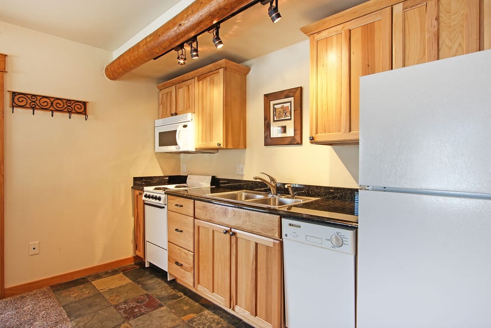 Small kitchen area has everything needed for a home cooked meal with electric stove, refrigerator, microwave and dishwasher.  