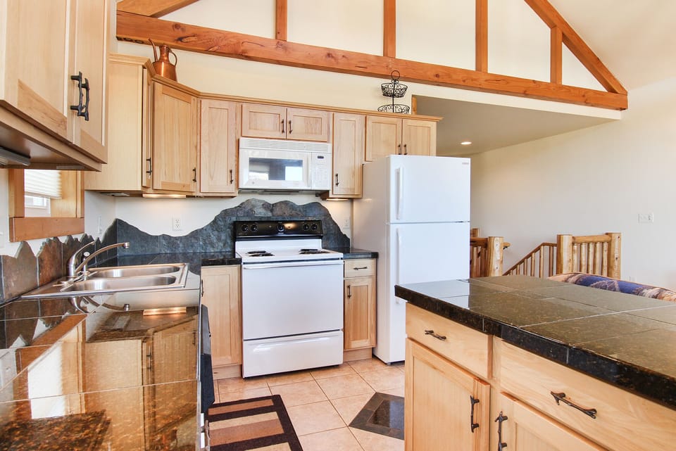 Beautifully decorated kitchen equipped with full size refrigerator and freezer, oven, stovetop, microwave and dishwasher. 