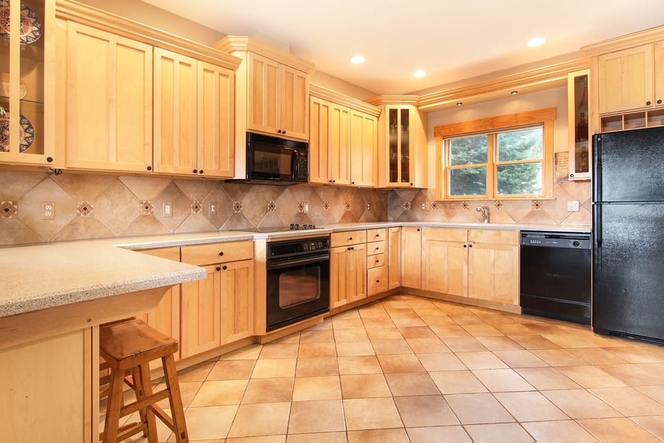 Full kitchen; equipped with oven, stovetop, dishwasher, microwave, and refrigerator. Plenty of counter and cabinet space. Countertop stool seating for two.