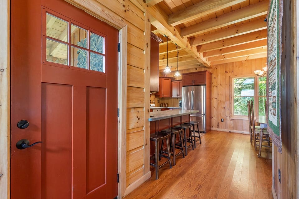 - Entryway opens to bright wooden interiors and open-concept kitchen   - Gather for morning coffee or evening chats at the breakfast bar   - Rustic design blends comfort and charm for a welcoming stay