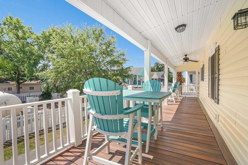 Spacious covered porch with cozy seating and tree-lined views